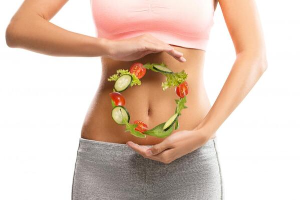 woman with vegetables hovering in front of her belly